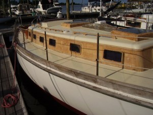 In the water and ready for non-skid.  Out from under the cover, I was concerned about the bare teak going grey, but I got the first coat of varnish on soon enough.